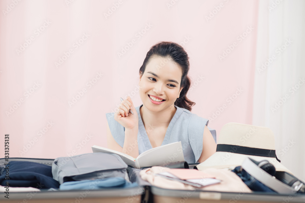 young asian pretty woman traveler smiling prepare and packing clothes into suitcase for holiday vacation at home young asian pretty woman traveler smiling prepare and packing clothes into suitcase for holiday vacation at home