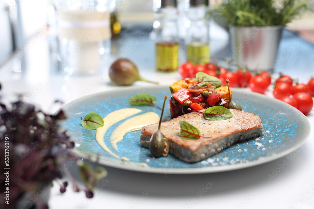 Grilled tuna steak with fried vegetables and parsley mousse.A plate with an appetizing dish. Application suggestion. Culinary photography, food stylization. Grilled tuna steak with fried vegetables and parsley mousse.A plate with an appetizing dish. Application suggestion. Culinary photography, food stylization.
