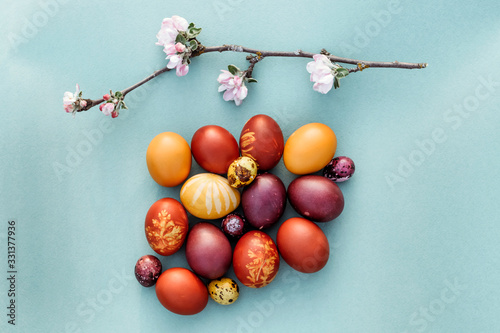 Easter background, multi-colored chicken and quail eggs on bright blue background.
