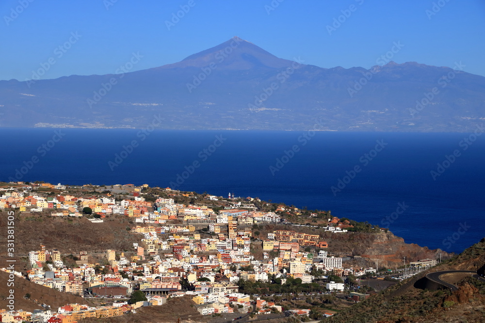 General view of San Sebastian de la Gomera with Teide Volcano (in Tenerife Island) in the background, La Gomera, Spain General view of San Sebastian de la Gomera with Teide Volcano (in Tenerife Island) in the background, La Gomera, Spain