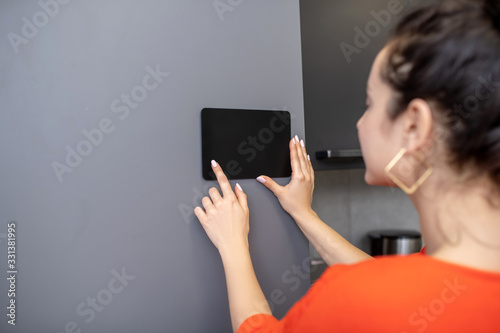 Woman hands holding tablet against grey wall