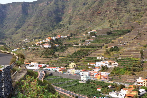 view to the village Hermigua on the Canary island La Gomera with multi colored houses and palm trees