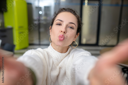 Young woman sending air kiss  holding out both hands