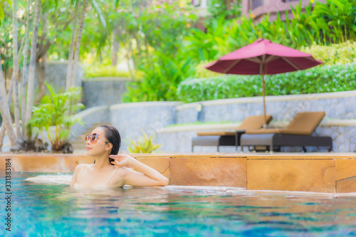 Portrait beautiful young asian woman relax around swimming pool in hotel resort