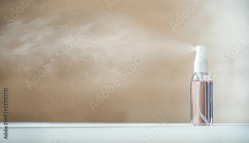 Disinfecting sanitizer bottle alcohol spray diffusing antibacterial sanitiser preventing spread of germs, bacterias, viruses on table. Personal hygiene, disinfection, coronavirus protection concept. photo