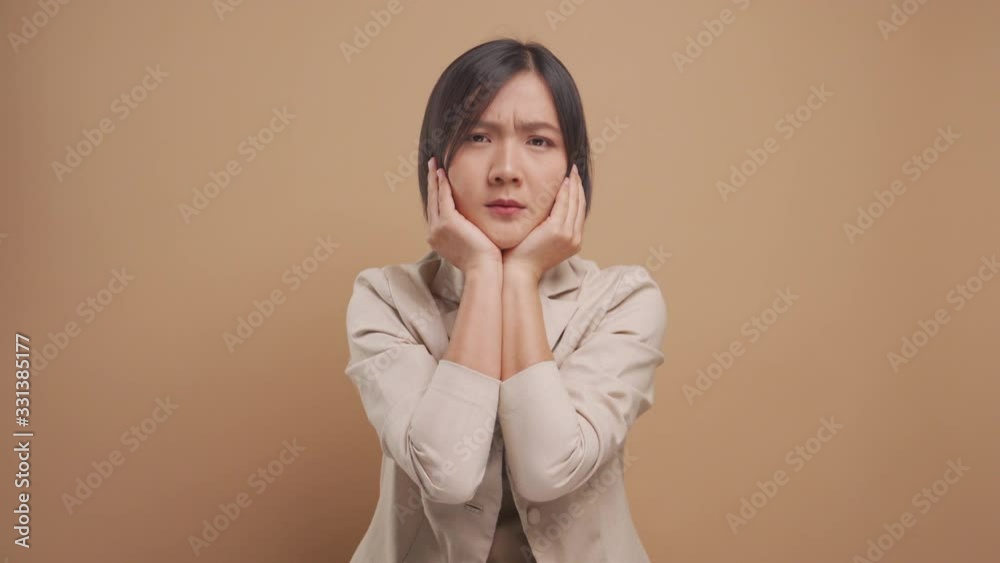 Asian business woman feel confused standing and looking at camera isolated over beige background. 4K video Asian business woman feel confused standing and looking at camera isolated over beige background. 4K video