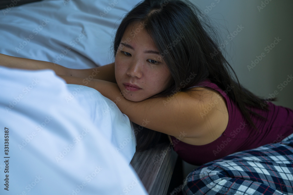 indoors portrait of young attractive sad and depressed Asian Korean woman at home on bedroom floor leaning on bed emotional and thoughtful feeling worried and scared indoors portrait of young attractive sad and depressed Asian Korean woman at home on bedroom floor leaning on bed emotional and thoughtful feeling worried and scared