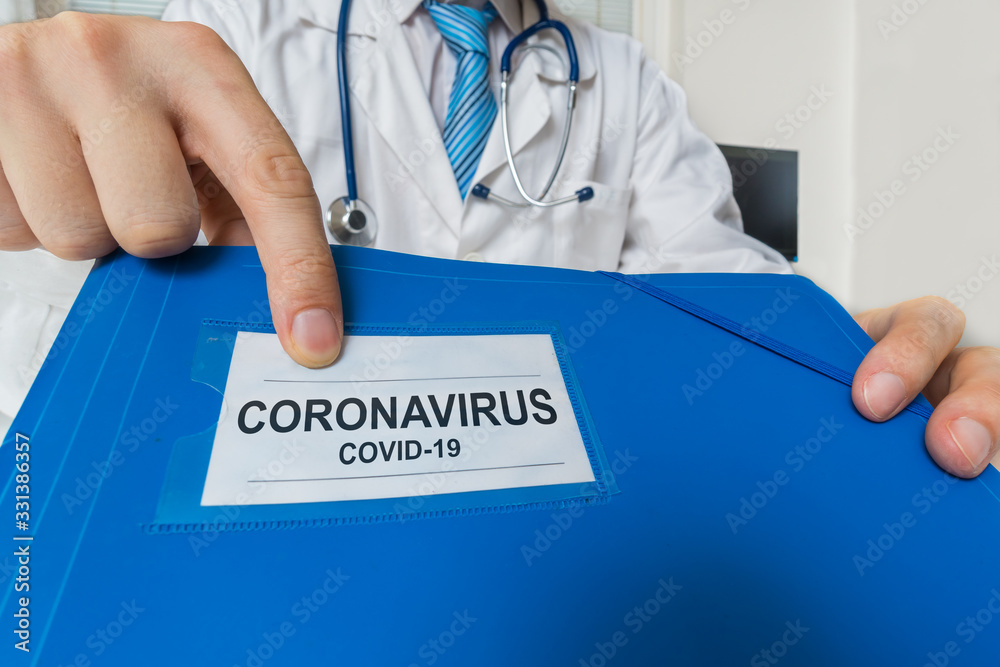 Doctor is holding blue folder with Coronavirus COVID-19 diagnosis. Doctor is holding blue folder with Coronavirus COVID-19 diagnosis.