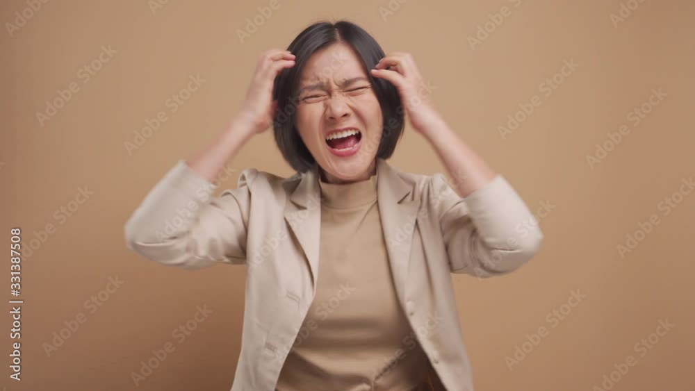 Asian business woman angry and screaming isolated over beige background. 4K video Asian business woman angry and screaming isolated over beige background. 4K video