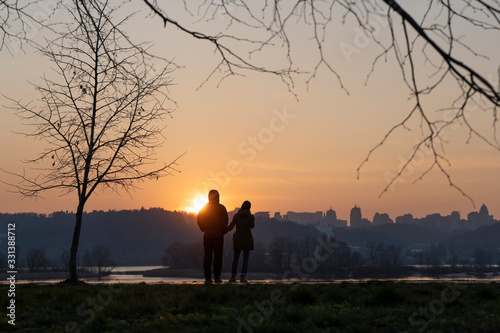 Cuople is looking on the sunset in the park