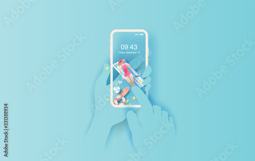 Hand holds smartphone with summertime application.Summer season with woman Sunbathing enjoy concept.Creative design paper cut and craft travel shopping online background.Travel accessories play beach