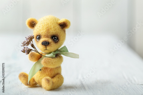 Teddy bear with bouquet of flowers on white wooden background. Card, banner, poster.  Space for text © 8H