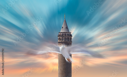 Galata Tower with flying abstract seagull on the background amazing sunset sky - Istanbul, Turkey