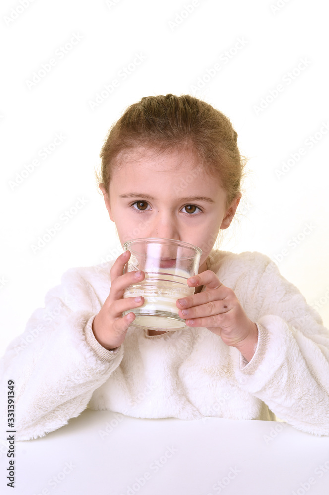 blonde girl with white clothes on a white background drinking a glass of milk blonde girl with white clothes on a white background drinking a glass of milk