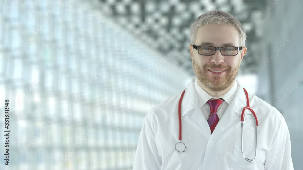 Portrait of a smiling assuring doctor in the modern hospital hall. Shot on Red camera Portrait of a smiling assuring doctor in the modern hospital hall. Shot on Red camera
