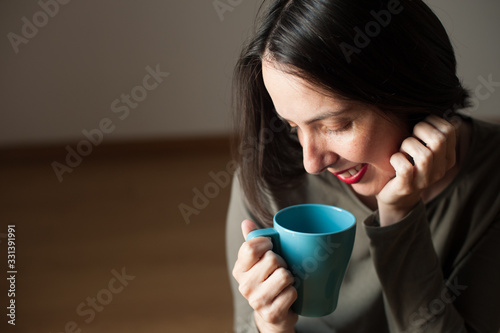 young peaceful happy woman drinking a beverage