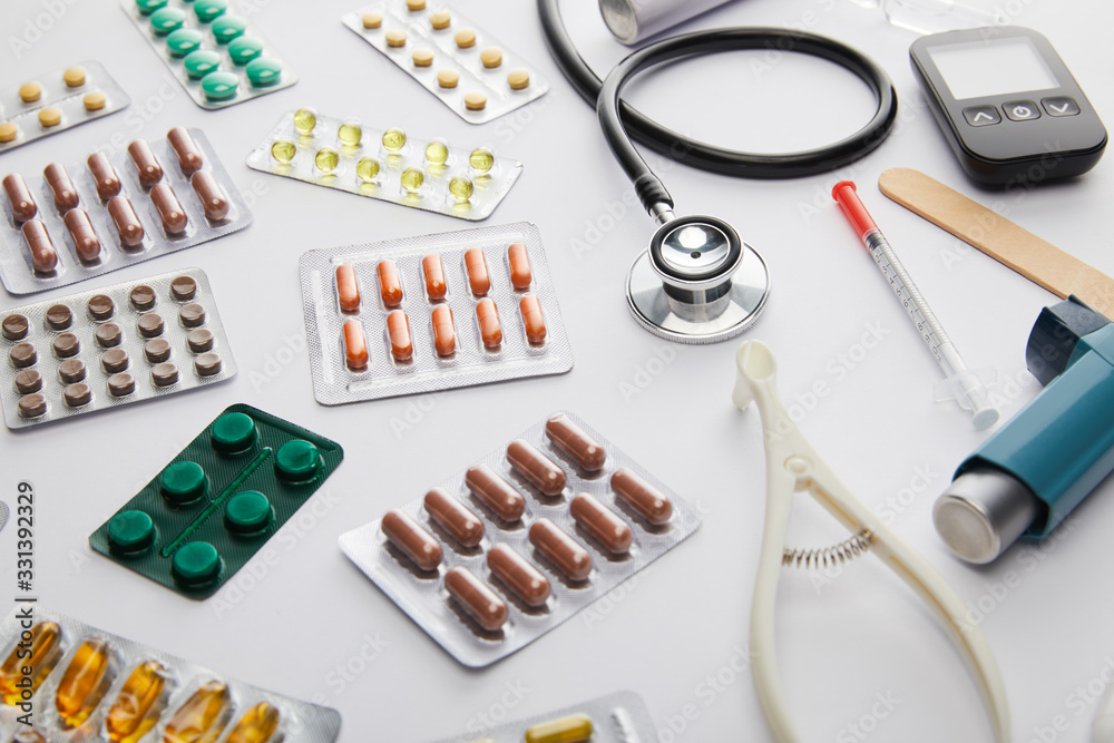 High angle view of medical objects and medicines on white background High angle view of medical objects and medicines on white background