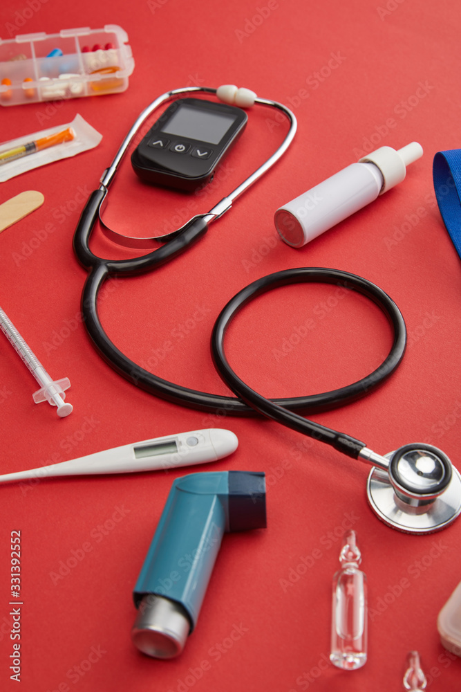 High Angle View of medical objects and medicines on red High Angle View of medical objects and medicines on red