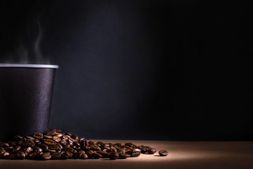 Küchenrückwand glas motiv Kaffee und Kaffeebohnen Schwarze Einwegtasse Kaffee mit Rauch und verstreuten Kaffeebohnen auf dunklem Hintergrund. Platz für Text  © elcovalana