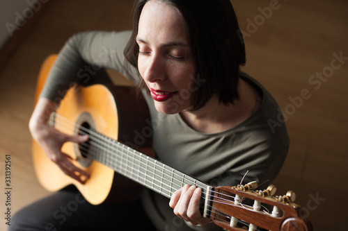 young peaceful woman playing the guitar