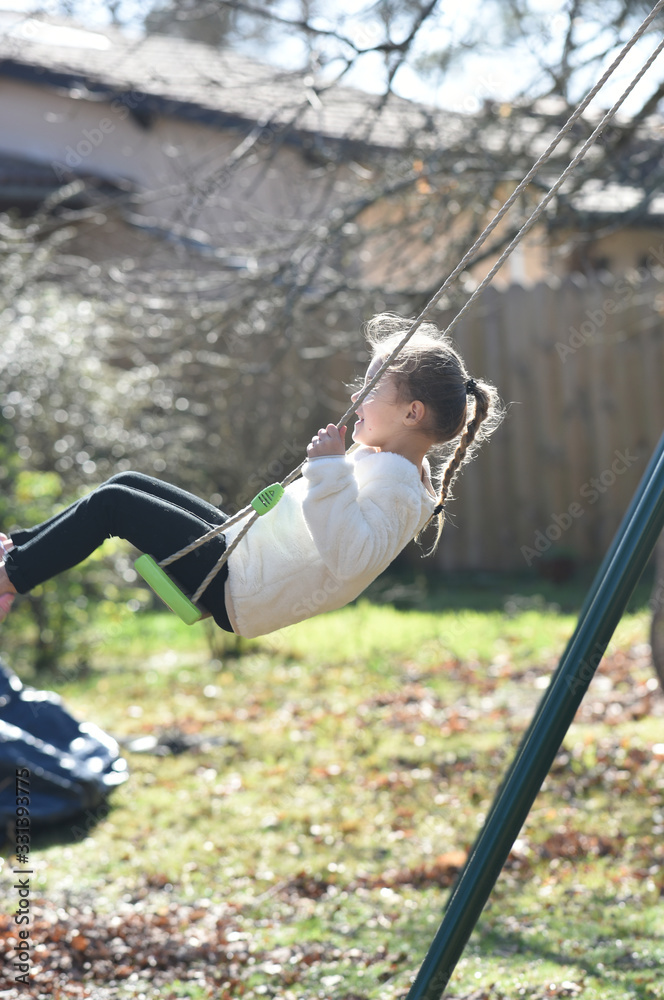 Obraz premium blonde girl on a swing with white sweater in profile