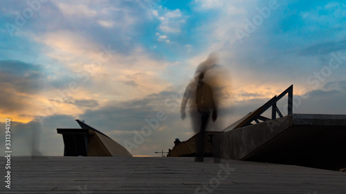 Silhouettes of people on the bridge long exposure photo. city people