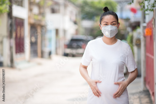 Pregnant asian woman wearing a mask To prevent pm 2.5 dust and corona virus, covid 19 concept