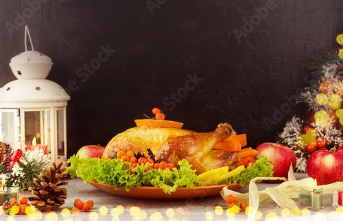 Roasted traditional Turkey with berries and apples on wooden table background with black backdrop. Christmas or thanksgiving holiday dinner