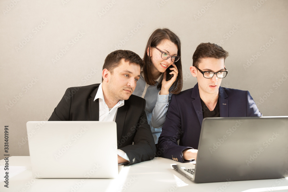 Young male and female business partners. Focused business team working, woman talking on mobile phone Young male and female business partners. Focused business team working, woman talking on mobile phone