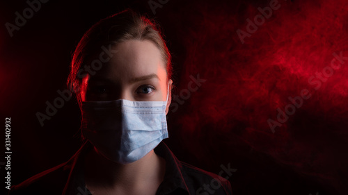 Coronavirus, girl in a mask on a black background. The title is about an outbreak of a coronavirus virus in the United States, Europe, Italy and Spain. epidemic. Photo for media headlines, news photo