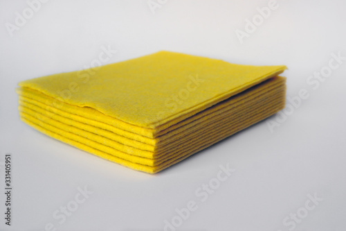Bright colored sponges for washing dishes, cleaning the bathroom and other household needs are located one above the other. Isolated. Close-up
