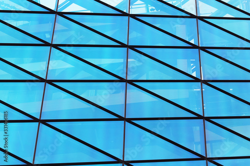 Glass window wall of modern building with blue sky reflection