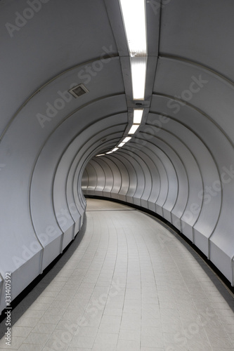 Curved walkway inside pedestrian crossing tunnel.