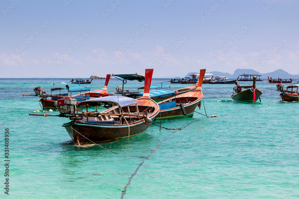 Thai traditional wooden long-tail boat and beautiful sand beach. Longtail boat on tropical island in Thailand. Tropical beach, longtail boats, Andaman Sea.