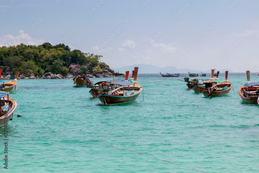 Thai traditional wooden long-tail boat and beautiful sand beach. Longtail boat on tropical island in Thailand. Tropical beach, longtail boats, Andaman Sea. Thai traditional wooden long-tail boat and beautiful sand beach. Longtail boat on tropical island in Thailand. Tropical beach, longtail boats, Andaman Sea.