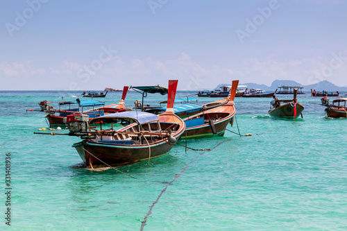 Thai traditional wooden long-tail boat and beautiful sand beach. Longtail boat on tropical island in Thailand. Tropical beach  longtail boats  Andaman Sea.