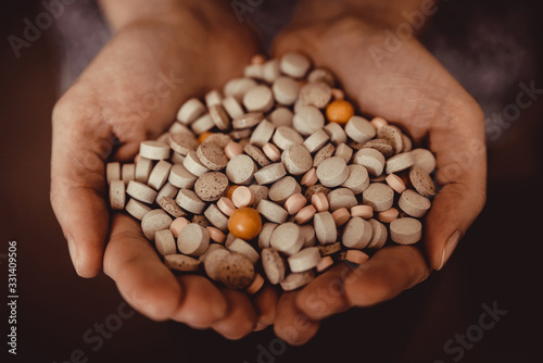 a large assortment of flu pills in hand