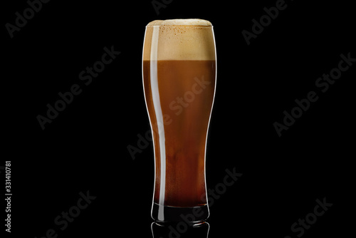 Weizen glass of black stout beer on a black background. Isolated studio shot with reflection.