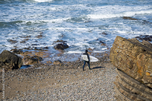 Foto Surfer at Bude in Cornwall heading out to the ocean