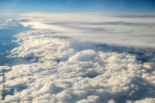 Aerial view of white puffy clouds viewed from an airplane.