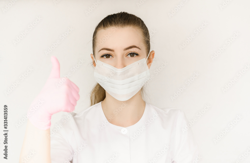 young successful girl doctor in protective mask and white coat shows sign with okay hand young successful girl doctor in protective mask and white coat shows sign with okay hand