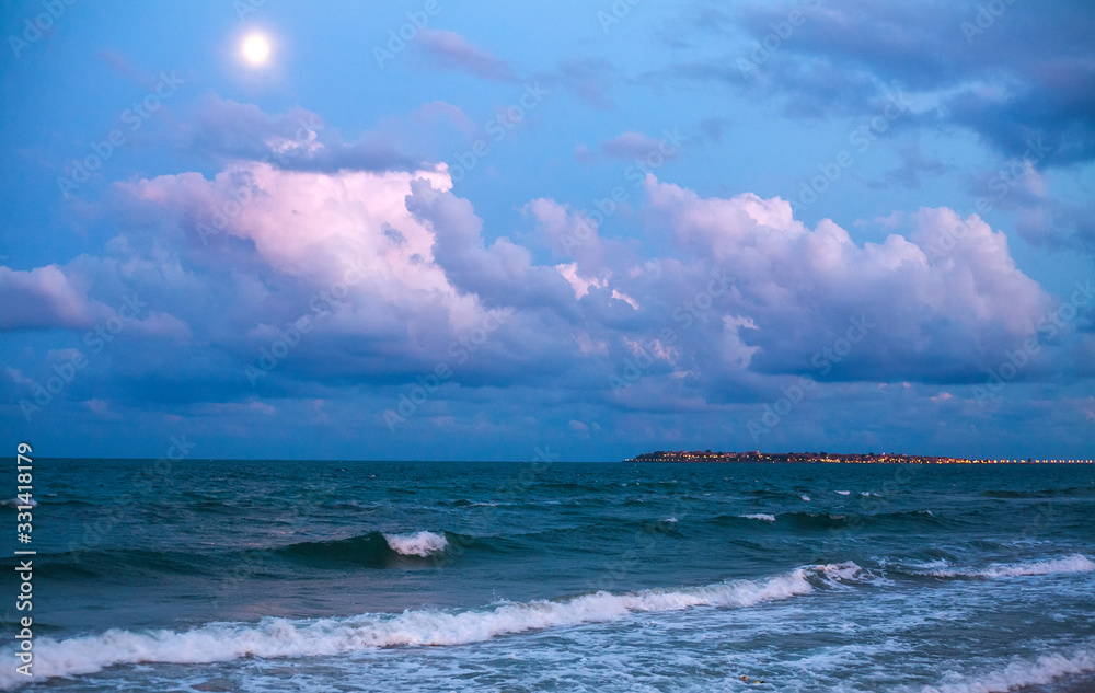Fototapeta premium Sea coast on background of beautiful sky with clouds and moon, beautiful relaxing evening view