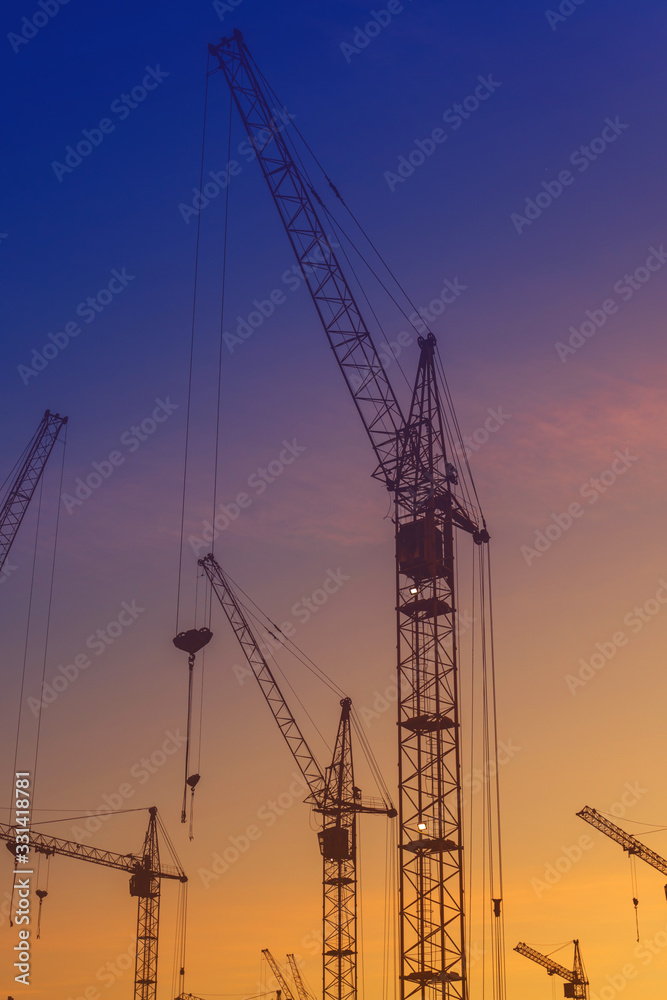 silhouettes of construction cranes at sunset. construction of buildings.