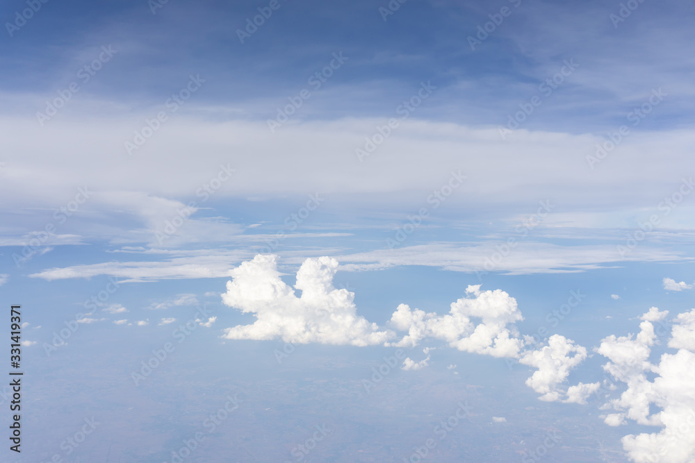 Skyscape view from clear glass window seat from aircraft to cloudscape, traveling on white fluffy clouds and vivid blue sky in a suny day Skyscape view from clear glass window seat from aircraft to cloudscape, traveling on white fluffy clouds and vivid blue sky in a suny day