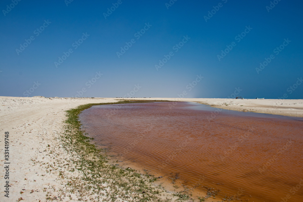 Pink Lagoon at white beach in Dhofar along the coastal road to Salalah in Oman