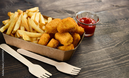 food delivery service. hot chicken nuggets and fries. take out food in a single use packaging made of recycled cardboard. takeaway food . selective focus and copy space photo