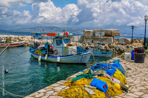 Wallpaper Mural Beautiful landscape with old small fisher boat, colorful fishing nets, calm sea water, blue sky with clouds and mountains on the horizon. Corfu Island, Greece. Torontodigital.ca
