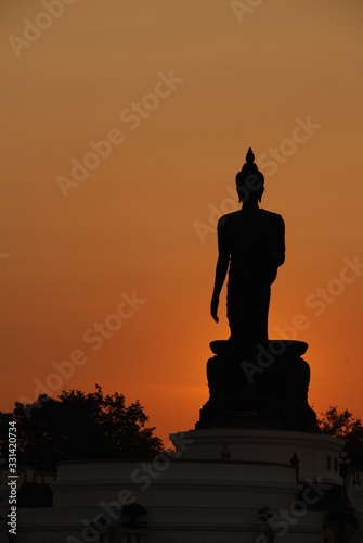 silhouette big buddha have orange sky background photo