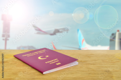 Public or tourist passport of Turkey on the table against to airport and flying plane. Travel concept photo for tourism company. Close up Turkish citizen ordinary passport.