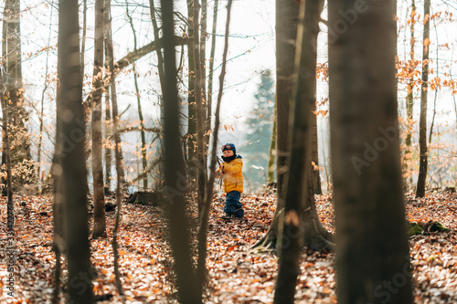 kleiner Junge spielt mit Stock im Wald 2